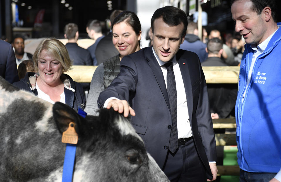 French President Emmanuel Macron discusses with a breeder as he visits the 56th International Agriculture Fair (Salon de l'Agriculture) at the Porte de Versailles exhibition center in Paris, France, Saturday, Feb. 23, 2019. Macron pledged to protect European farming standards and culinary traditions threatened by aggressive foreign trade practices that see food as a "product like any other." (Julien de Rosa/Pool Photo via AP)