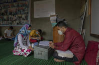 Iqra Nazir listens to her teacher Muneer Ahmed during a math coaching class in Srinagar, Indian controlled Kashmir, Wednesday, July 22, 2020. Decades of insurgency, protests and military crackdowns have constantly disrupted formal schooling in Indian-administered Kashmir, where rebels have fought for decades for independence or unification with Pakistan, which controls the other part of the Muslim-majority region. Over the years, volunteer-run community schools and makeshift classrooms have emerged to fill the gap when formal schools shut down, but large-scale troop deployments and restrictions on public movement mean they reach only a small proportion of students. (AP Photo/Dar Yasin)