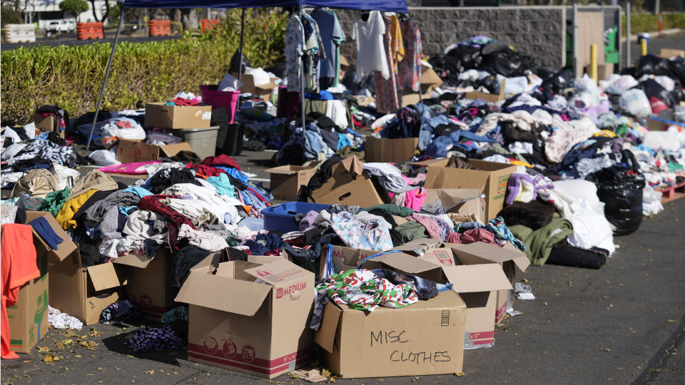 Donated clothes are gathered in a parking lot, Sunday, Aug. 13, 2023, in Lahaina, Hawaii, following wildfires that caused heavy damage. (AP Photo/Rick Bowmer)