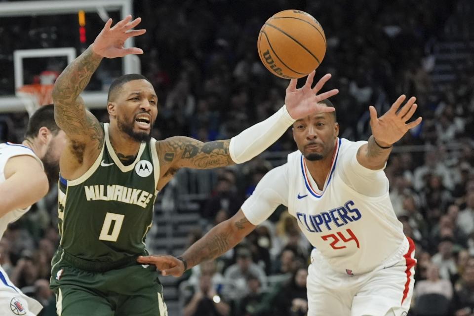 LA Clippers' Norman Powell knocks the ball from Milwaukee Bucks' Damian Lillard during the first half of an NBA basketball game Monday, March 4, 2024, in Milwaukee. (AP Photo/Morry Gash)