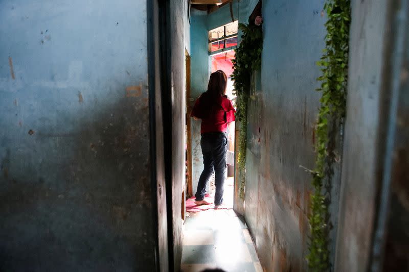 Eva, a 45-year-old trans woman who works as a busker stands near her rented room in Jakarta