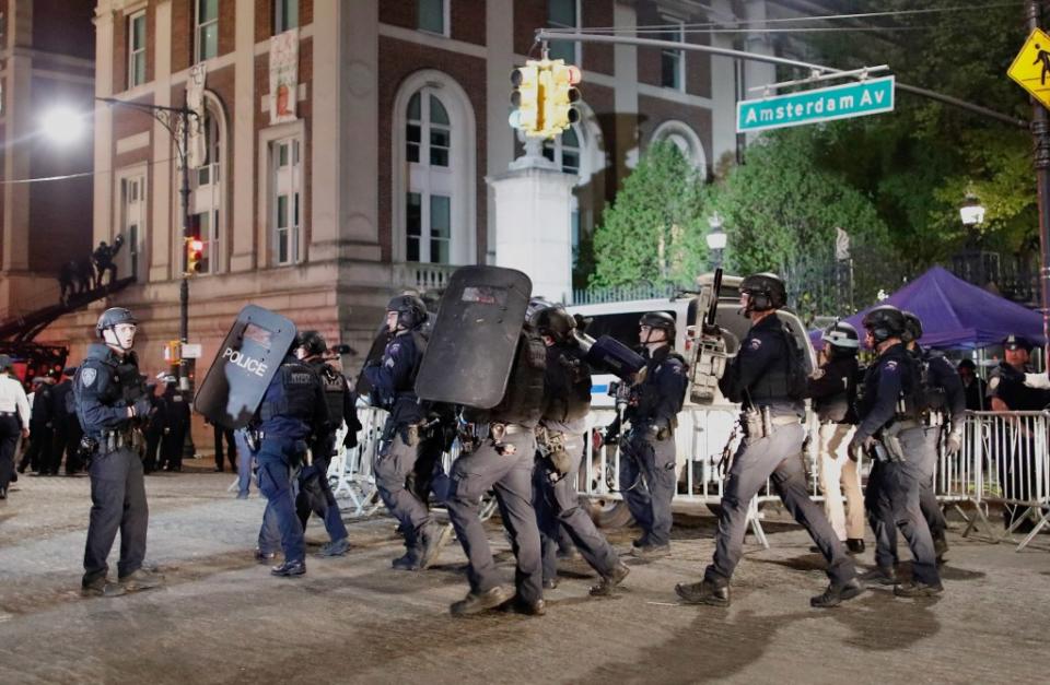 NYPD officers arrive in riot gear Tuesday night. AFP via Getty Images