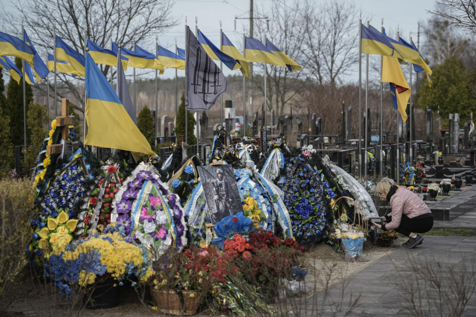 Woman cares on the grave of a relative killed in combat at the cemetery in Bucha, outskirts of Kyiv, Saturday March 30, 2024. Ukrainians mark the 2nd anniversary of the liberation of Bucha Sunday. Russian occupation left hundreds of civilians dead in the streets and in mass graves in Bucha during the initial months of the Russian invasion in 2022.(AP Photo/Enric Marti)