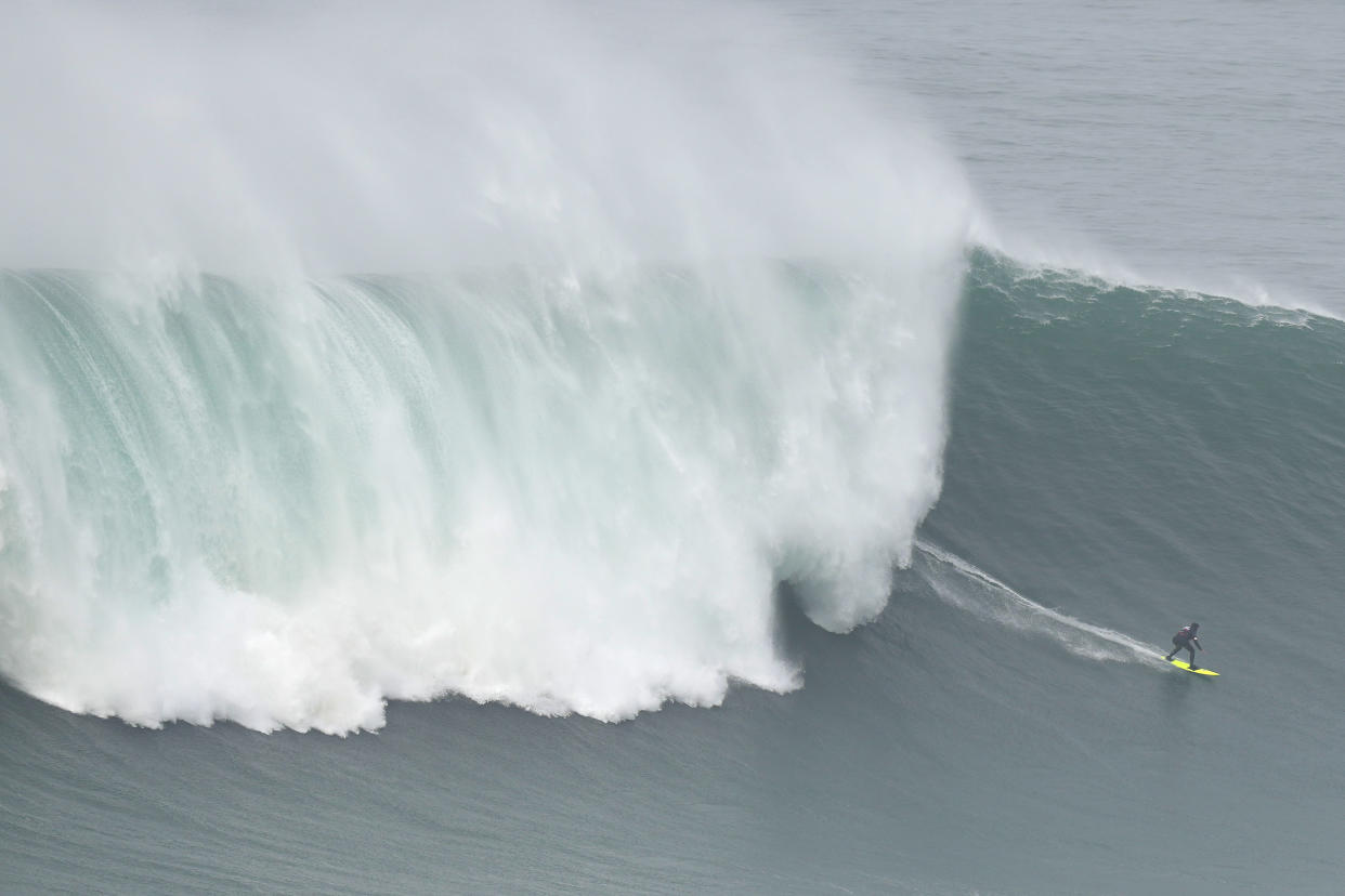 Surfer Maya Gabeira from Brazil rides a wave during the Nazare Tow Challenge big wave surfing competition at Praia do Norte, or North Beach, in Nazare, Portugal, Thursday, Feb. 10, 2022. (AP Photo/Armando Franca)