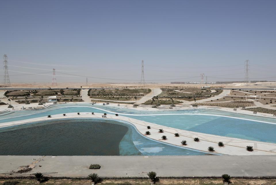 FILE- The central park is under construction, part of a planned 21-mile-long public park, in the New Administrative Capital, 45 kilometers (28 miles) east of Cairo, Egypt on Oct. 18 2017. Egypt’s president has ordered his administration to start moving its offices next month to a sprawling new administrative capital in the desert outside Cairo. President Abdel Fattah el-Sissi has directed the government to begin working from the new complex starting Dec. 1, 2021. (AP Photo/Nariman El-Mofty, File)