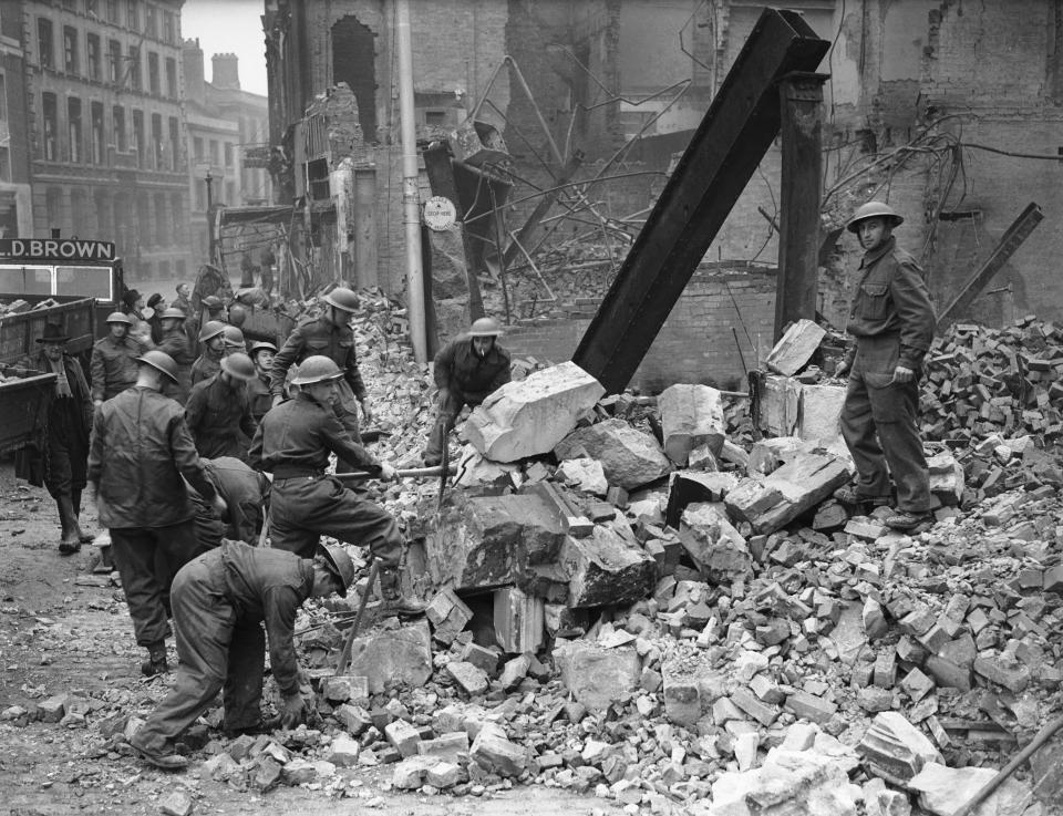 18th November 1940: Soldiers brought in to Coventry to help with the clear up following the heavy German air raid of the 14th November 1940. During the raid 4,330 homes were destroyed also three-quarters of the city's factories were damaged along with the city's tram system. Out of a fleet of 181 buses only 73 remained. Most of the city's gas and water pipes were smashed and people were advised to boil emergency supplies of water. Amongst the devastation lay the bodies of 554 men, women and children many of whom were never identified also 865 people were injured. During the raid the Luftwaffe had dropped 30,000 incendiary bombs, 500 tons of high explosive, 50 landmines and 20 oil-mines. The raid had gone on non-stop for almost eleven hours. The world had never previously witnessed this sort of airborne destruction before and the Germans coined a new word for it 'coventrated' (Photo by Birmingham Post and Mail/Mirrorpix/Mirrorpix via Getty Images)