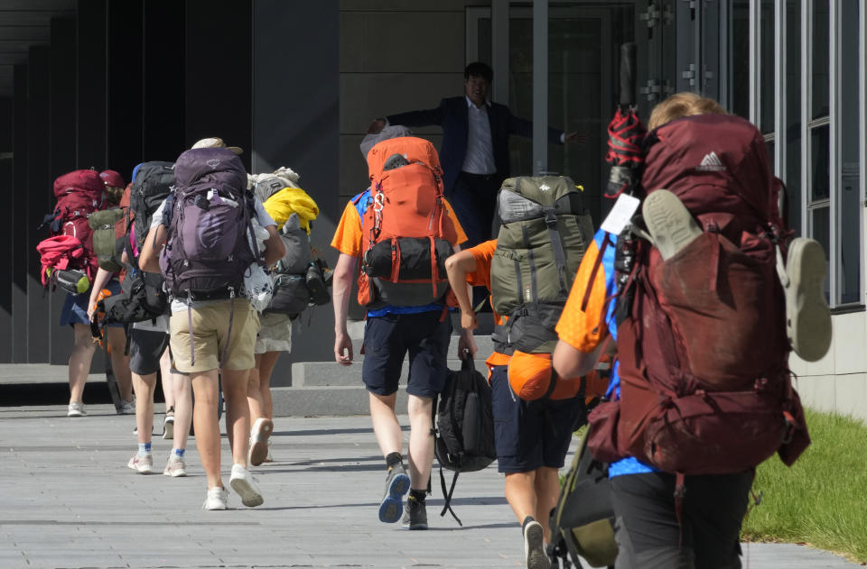 Asistentes al Jamboree Scout Mundial llegan desde un campamento de exploradores en una instalación de Hyundai Motor Group en Yongin, Corea del Sur, el martes 8 de agosto de 2023. Los autobuses comenzaron a trasladar a decenas de miles de Scouts a lugares del interior el martes antes de una tormenta tropical. (Foto AP/Ahn Young-joon)