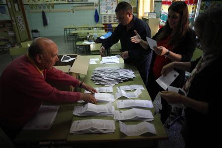 Members of the electoral table count the ballots next to a member (L) of the Socialist Workers' Party (PSOE) after the European Parliament elections at a polling station in Ronda, near Malaga, southern Spain, May 25, 2014. REUTERS/Jon Nazca