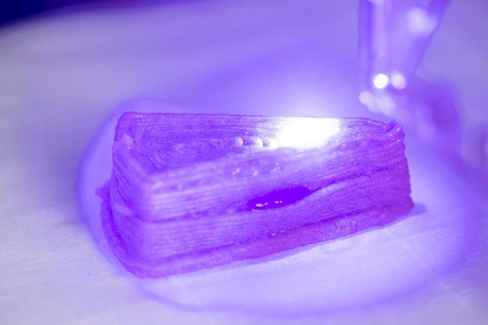 A blue laser broiling the top layer of graham cracker from a seven-ingredient printed dessert.