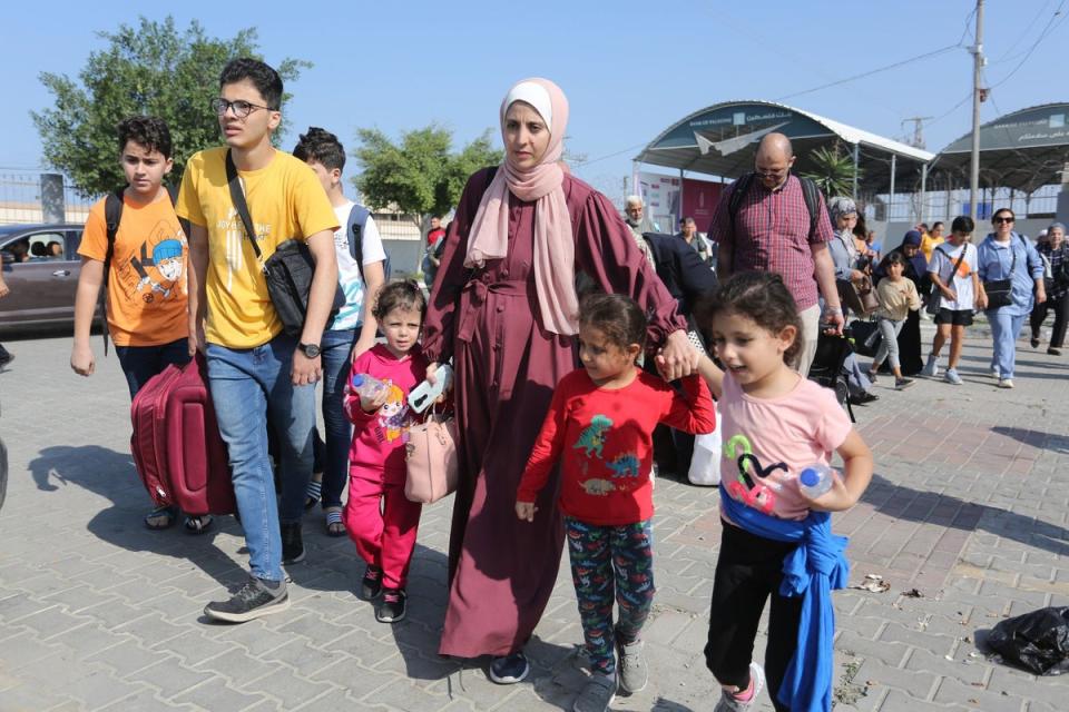 Palestinians cross to the Egyptian side of the border crossing with the Gaza Strip in Rafah on Wednesday (AP)