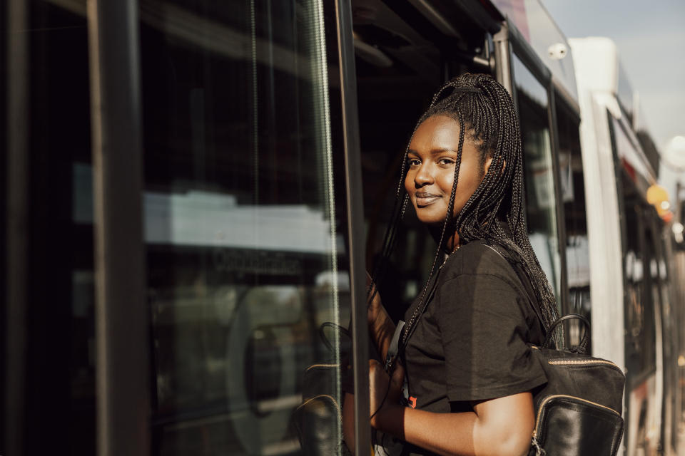 A smiling woman getting on a train