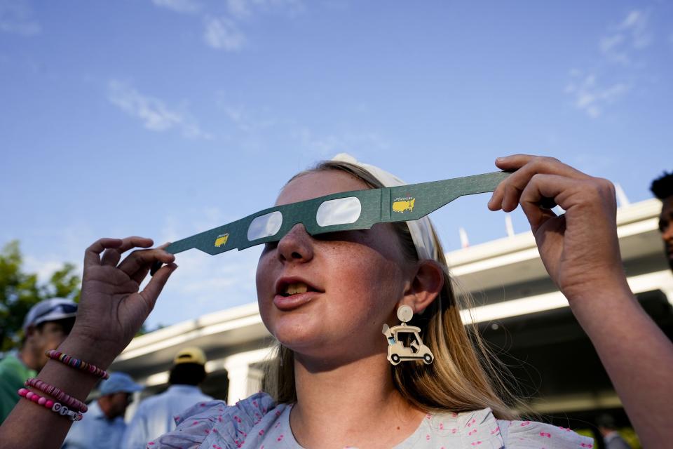 Aubrey Fender, 11, tries on eclipse glasses during a practice round for the Masters Tournament golf tournament at Augusta National Golf Club on April 8, 2024 in Augusta, Ga.