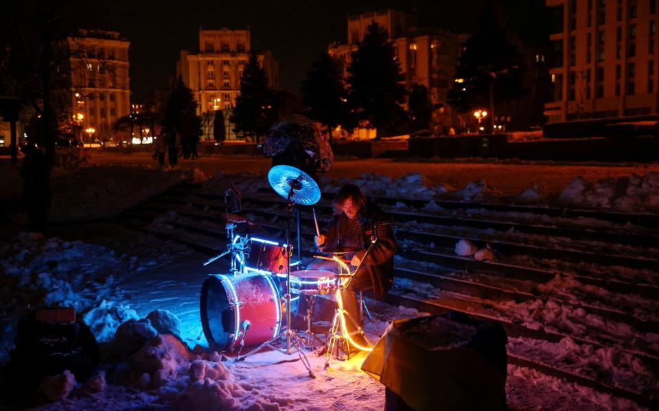 A street musician plays drums during power outages in Kyiv - Shannon Stapleton/Reuters
