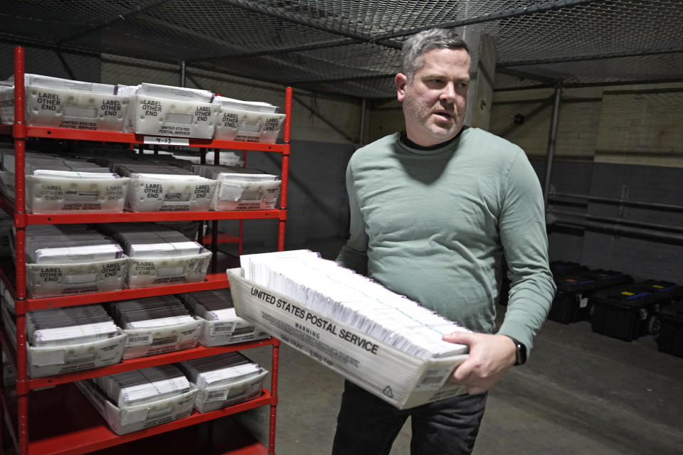 FILE - Allegheny County Election Division Deputy Manager Chet Harhut carries a container of mail-in ballots in Pittsburgh, April 18, 2024. The Republican National Committee has filed voting-related lawsuits in two dozen states targeting such things as voter rolls, mailed balloting and policies related to poll watchers. Democrats say it’s a strategy designed to raise doubts about the legitimacy of the vote this fall and potentially delay certification of the results. (AP Photo/Gene J. Puskar, File)