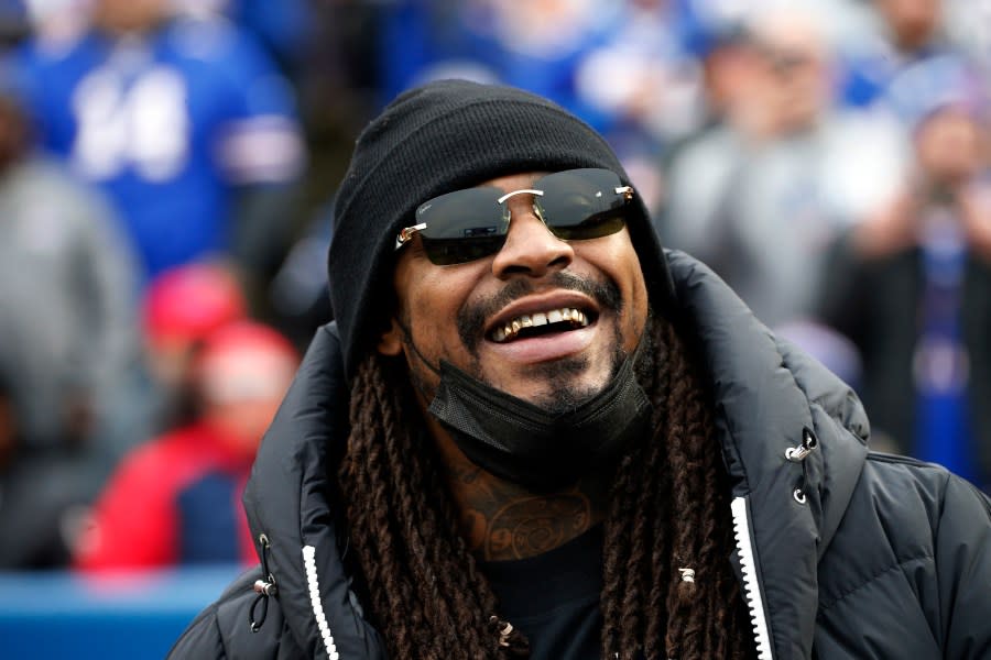 <em>FILE – Marshawn Lynch stands on the field before an NFL football game between the Buffalo Bills and the Indianapolis Colts in Orchard Park, N.Y., Nov. 21, 2021. (AP Photo/Jeffrey T. Barnes, File)</em>