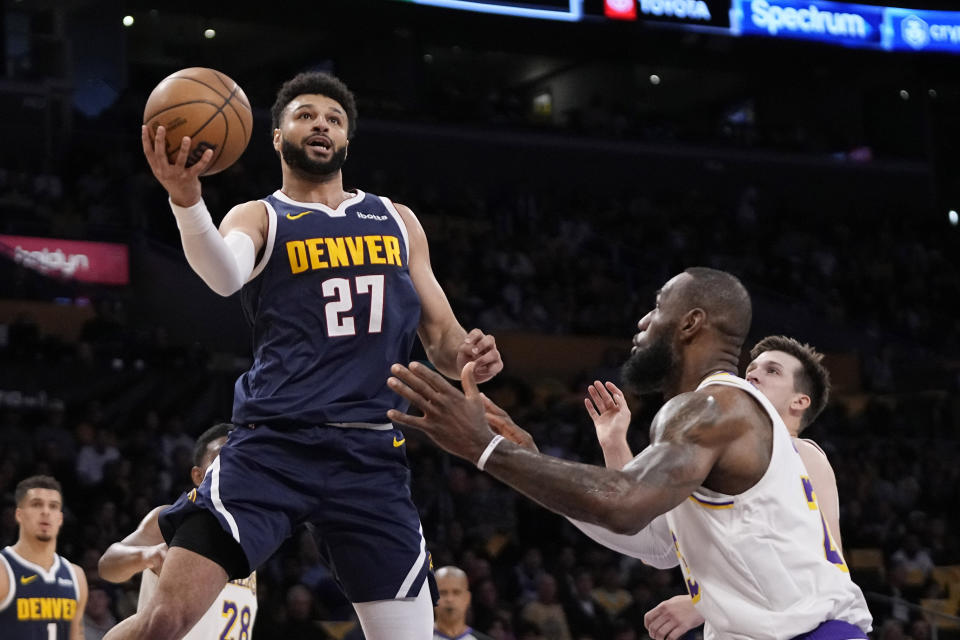 Denver Nuggets guard Jamal Murray, left, shoots as Los Angeles Lakers forward LeBron James defends during the first half in Game 4 of an NBA basketball first-round playoff series Saturday, April 27, 2024, in Los Angeles. (AP Photo/Mark J. Terrill)