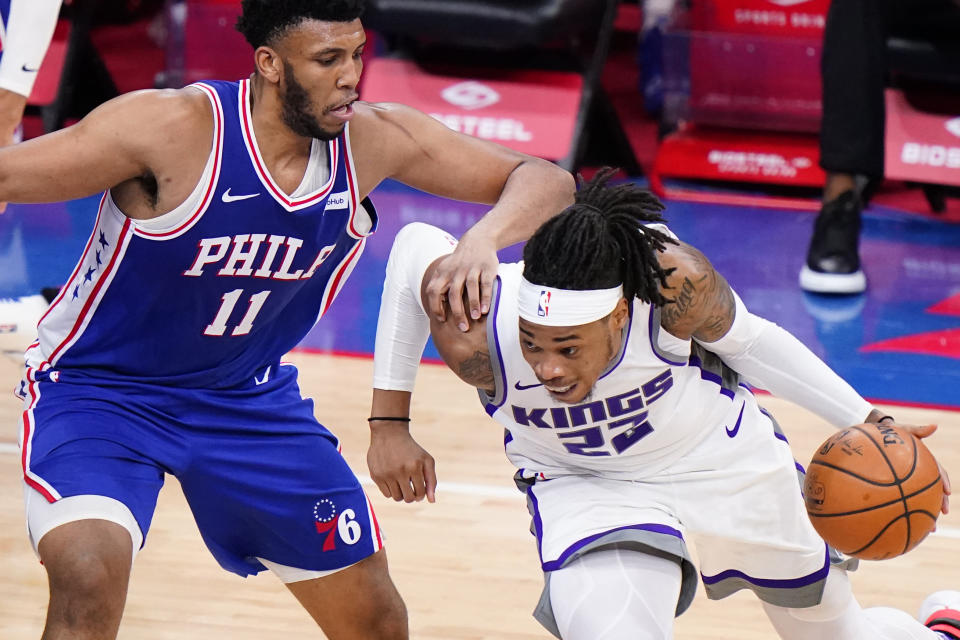 Sacramento Kings' Richaun Holmes, right, tries to dribble past Philadelphia 76ers' Tony Bradley during the second half of an NBA basketball game, Saturday, March 20, 2021, in Philadelphia. (AP Photo/Matt Slocum)