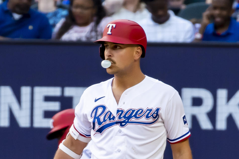 Texas Rangers first baseman Nathaniel Lowe blows a bubble during an at-bat in the third inning of the team's baseball game against the Philadelphia Phillies in Arlington, Texas, Saturday, April 1, 2023. (AP Photo/Emil T. Lippe)