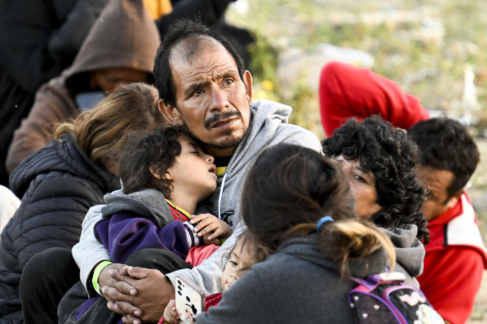 Asylum-seekers wait between the double fence on U.S. soil along the U.S.-Mexico border near Tijuana, Mexico, on May 8, 2023, in San Diego. The migrants wait between the fences to be processed by U.S. Border Patrol agents. (AP Photo/Denis Poroy)