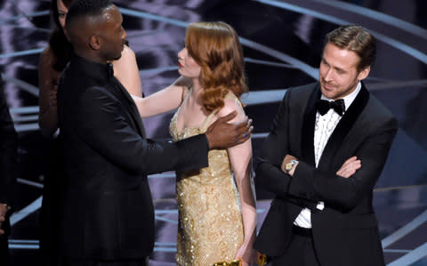 Emma Stone congratulates Mahershala Ali, of Moonlight, after the error is revealed while Ryan Gosling stands arms folded - Credit: Invision/AP