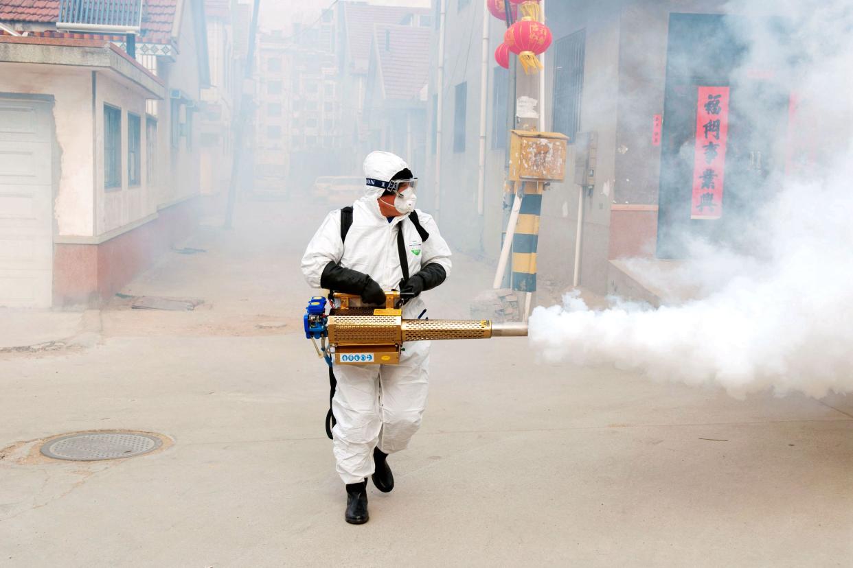 A Chinese volunteer wearing the protective clothing disinfects a street for prevention of the new coronavirus and pneumonia during the Chinese New Year or Spring Festival holiday in Dongxinzhuang Village, Qingdao City, east China's Shandong Province on January 29th, 2020. (Photo by Yu Fangping / Costfoto/Sipa USA)