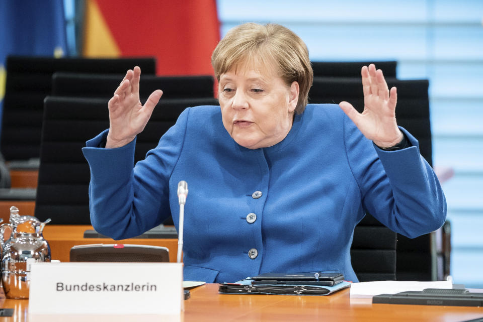 German Chancellor Angela Merkel gestures during the weekly cabinet meeting at the Chancellery in Berlin, Germany, Wednesday, March 18, 2020. Due to the new coronavirus outbreak the meeting was reloacted to the International Room to provide more space between the participants. For most people, the new coronavirus causes only mild or moderate symptoms. For some it can cause more severe illness, especially in older adults and people with existing health problems. (Michael Kappeler/DPA via AP, Pool)