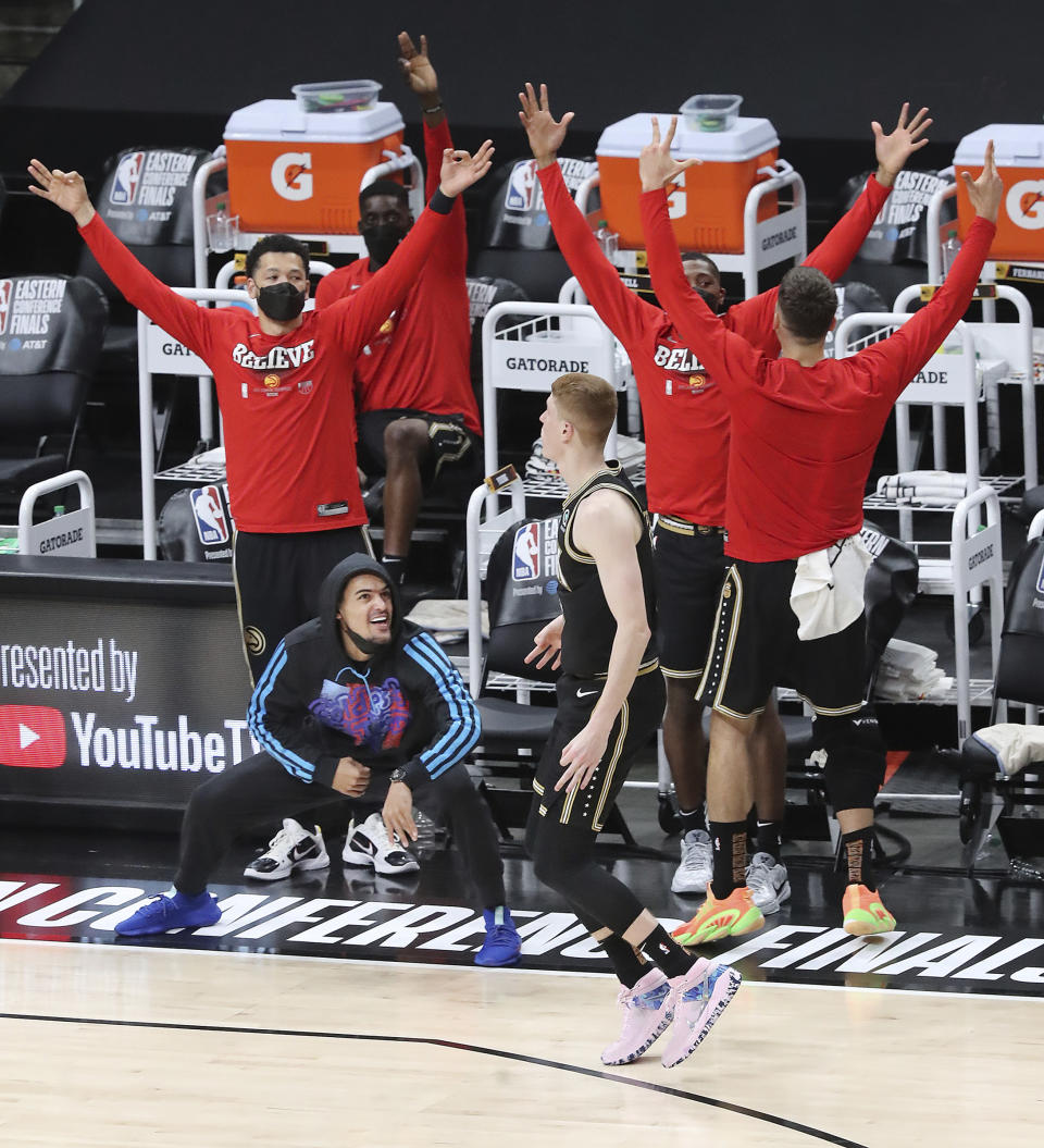 Injured Atlanta Hawks guard Trae Young and the bench react as Kevin Huerter hits a 3-pointer against the Milwaukee Bucks during the fourth quarter in Game 4 of the Eastern Conference finals in the NBA basketball playoffs Tuesday, June 29, 2021, in Atlanta. (Curtis Compton/Atlanta Journal-Constitution via AP)