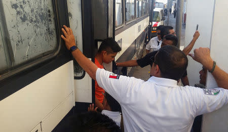 A migrant gets off from a police bus carrying rescued migrants, after 115 migrants were rescued from a lorry by police, in Veracruz Port, Mexico August 19, 2017. Picture taken on August 19, 2017. REUTERS/Roxana Irais