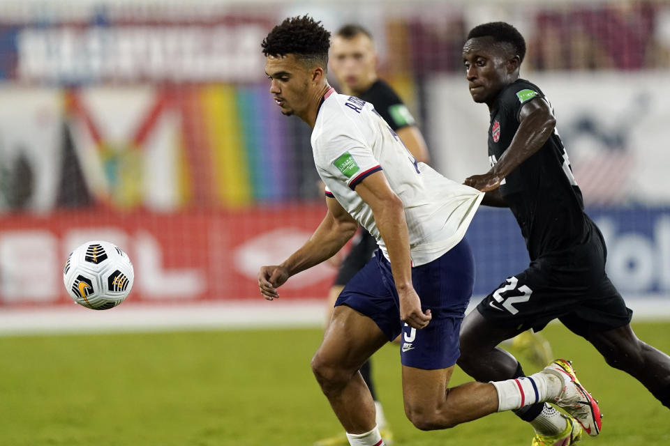 Canada defender Richie Laryea (22) grabs the shirt of United States defender Antonee Robinson (5) during the second half of a World Cup soccer qualifier Sunday, Sept. 5, 2021, in Nashville, Tenn. (AP Photo/Mark Humphrey)