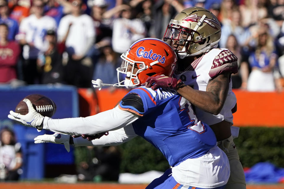 Florida cornerback Jason Marshall Jr., left, intercepts a pass intended for Florida State wide receiver Andrew Parchment during the second half of an NCAA college football game, Saturday, Nov. 27, 2021, in Gainesville, Fla. (AP Photo/John Raoux)