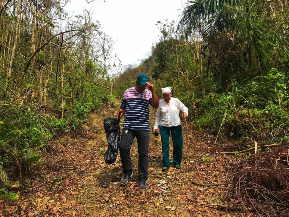 Jesse Vazquez and his mother, Mercedes Mercado, hike along a muddy path to their farm in Hatillo, Puerto Rico, on Oct. 10, 2017, to survey the damage from Hurricane Maria. (Photo: Caitlin Dickson/Yahoo News)