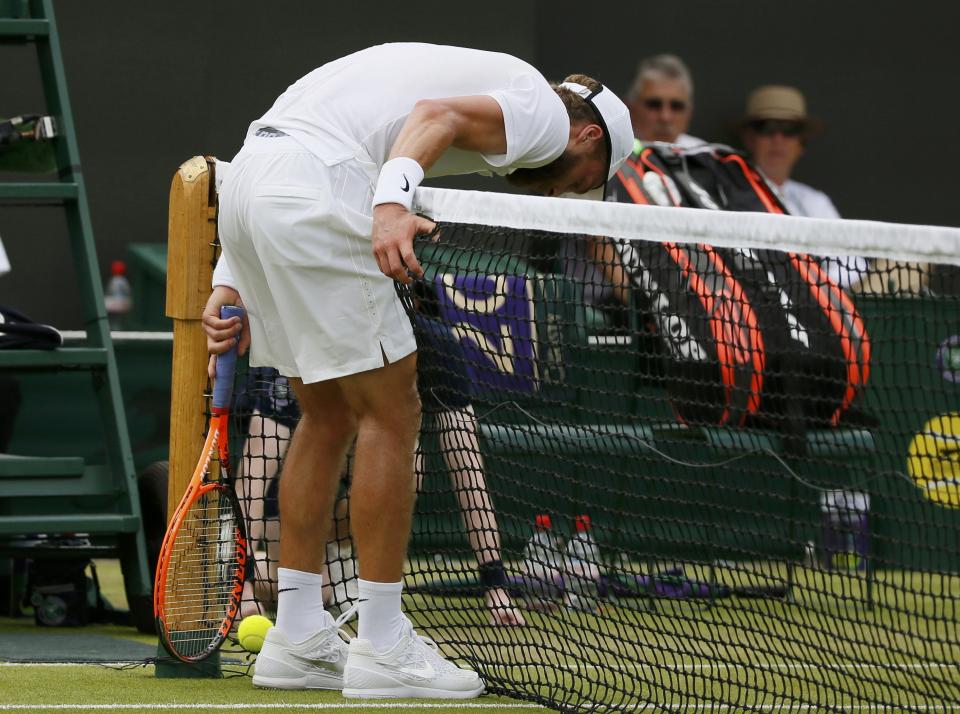 Liam Broady of Britain runs into the net after scrambling for the ball during his match against David Goffin of Belgium at the Wimbledon Tennis Championships in London, July 1, 2015. REUTERS/Stefan Wermuth