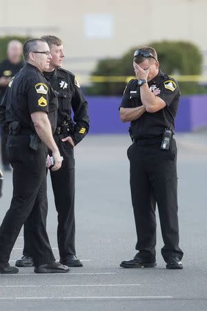 Sacramento County Sheriff Lieutenant Palmer covers his face while gathered with fellow officers near a Motel 6 parking lot where Sheriff's Deputy Danny Oliver was killed in Sacramento, California October 24, 2014. REUTERS/Noah Berger