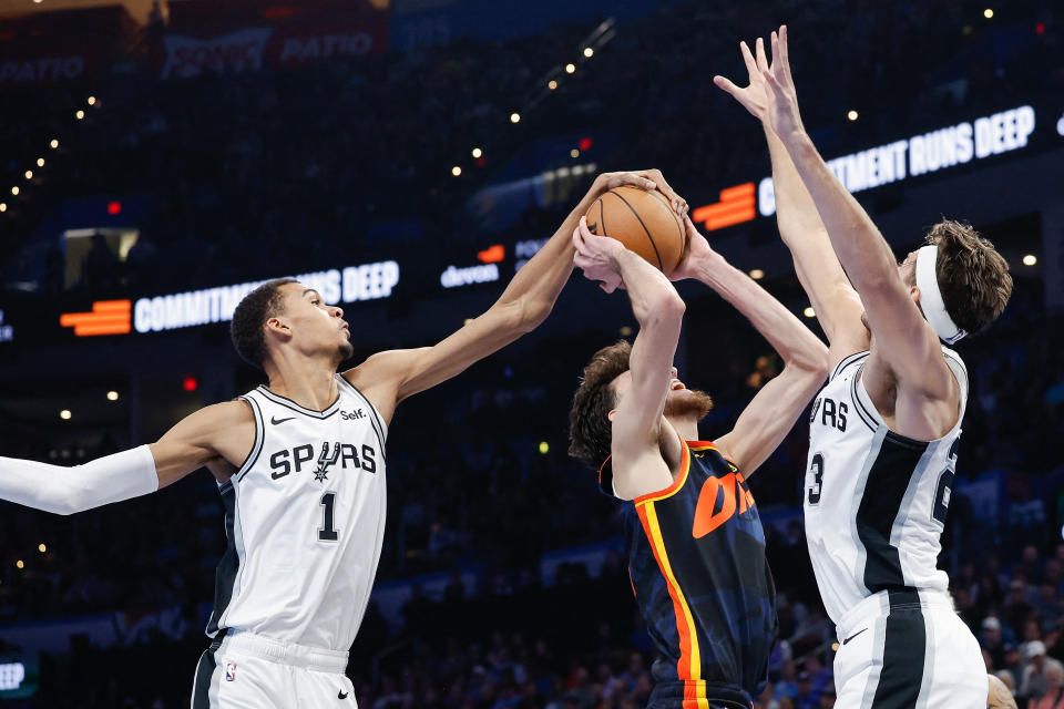 Spurs uzbrucējs Viktors Vimpaņama 2023. gada 14. novembrī Paycom centrā Oklahomsitijā pirmās regulārās sezonas spēles otrajā pusē atvairīja Thunder centra centra Četa Holmgrēna metienu. (Alonzo Adams/USA TODAY Sports)