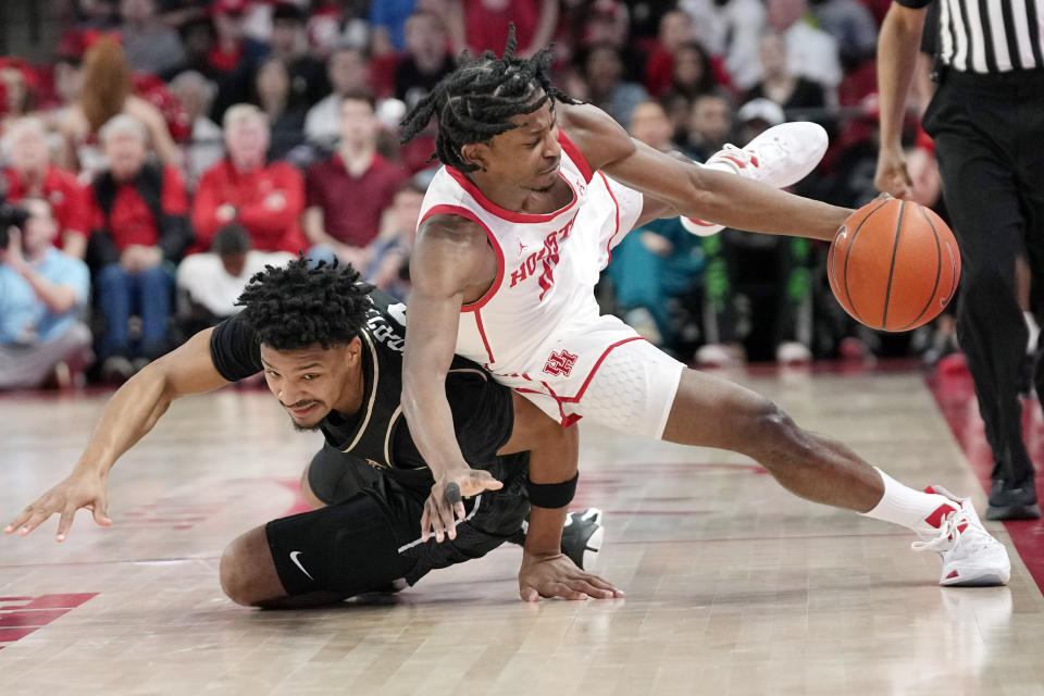 Houston's Tramon Mark, right, is fouled by Central Florida's Ithiel Horton during the first half of an NCAA college basketball game Saturday, Dec. 31, 2022, in Houston. (AP Photo/David J. Phillip)