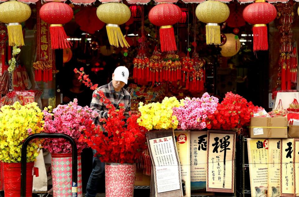 PHOTO: Chinese New Year celebratory items, including synthetic flowers and banners, add splashes of color to Broadway in Chinatown on a mostly cloudy day in Los Angeles on Jan. 2, 2024.  (Luis Sinco/Los Angeles Times via Getty Images)