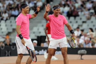 Trevor Noah and Rafael Nadal high five after winning a point against Roger Federer and Bill Gate in the exhibition match held at the Cape Town Stadium in Cape Town, South Africa, Friday Feb. 7, 2020. (AP Photo/Halden Krog)