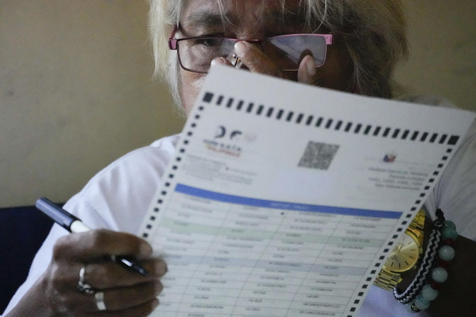 A woman adjusts her eyeglasses as she votes at a polling center Monday, May 9, 2022 in Quezon City, Philippines. Filipinos were voting for a new president Monday, with the son of an ousted dictator and a champion of reforms and human rights as top contenders in a tenuous moment in a deeply divided Asian democracy. (AP Photo/Aaron Favila)