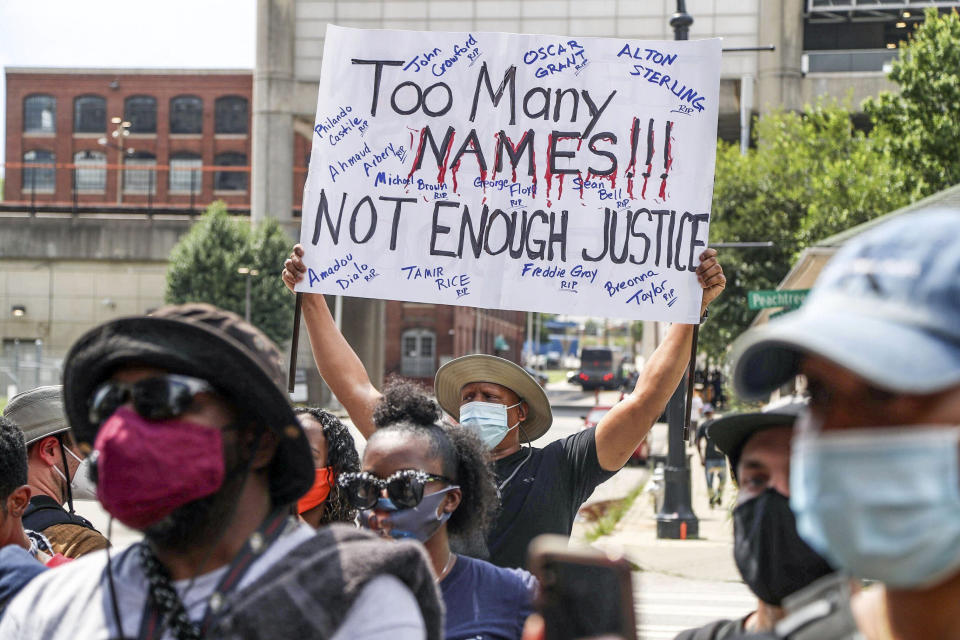 A demonstrator carries a sign as he joins others rallying outside of the Atlanta City Detention Center in Atlanta on Sunday, June 14, 2020. Rayshard Brooks died after a confrontation with police officers at a fast food restaurant in Atlanta on Friday. (Alyssa Pointer/Atlanta Journal-Constitution via AP)