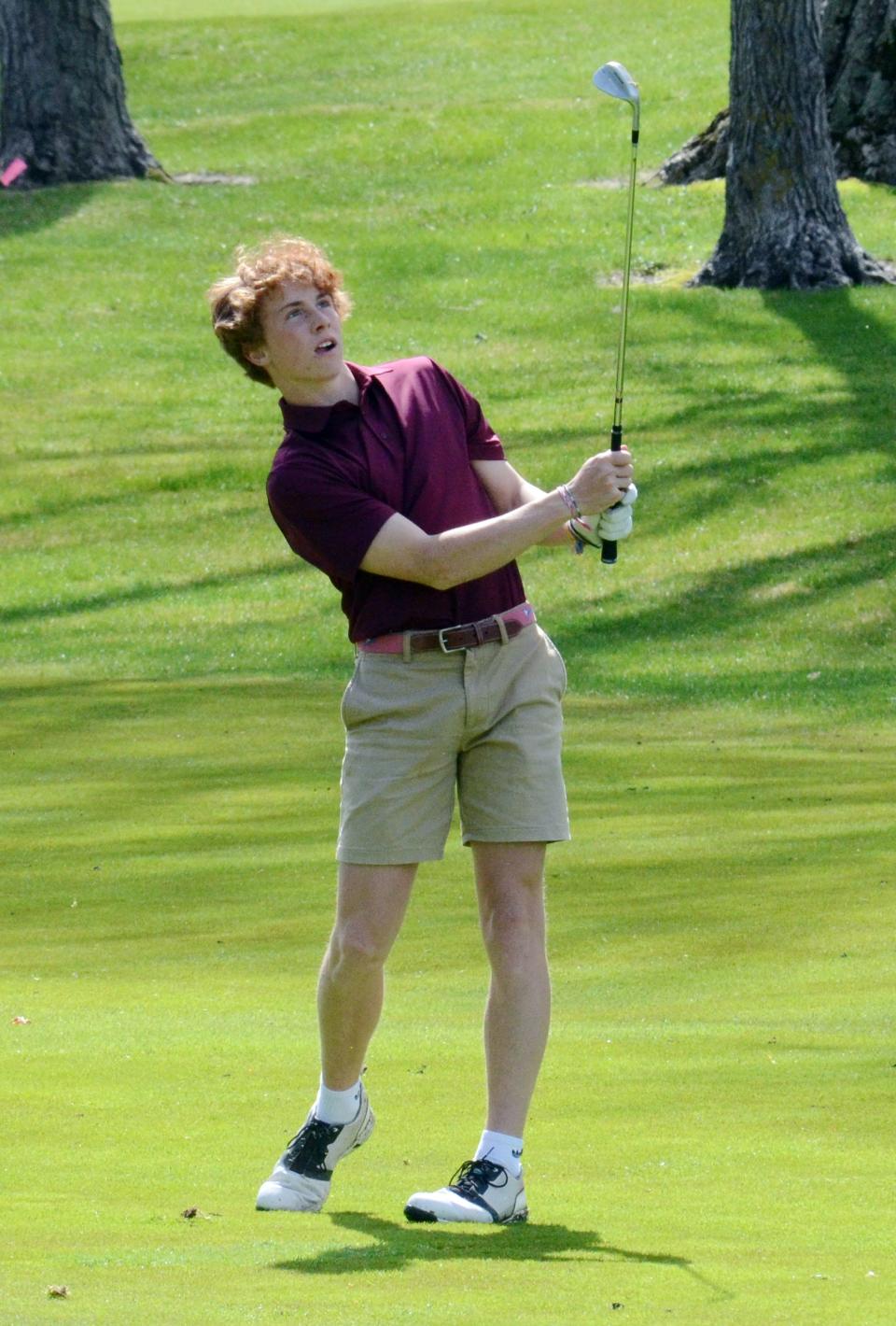 Charlevoix's Hudson Vollmer watches his approach shot during Monday's round.