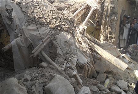 Residents stand at the site of a drone attack on an Islamic seminary in Hangu district, bordering North Waziristan November 21, 2013. REUTERS/Syed Shah