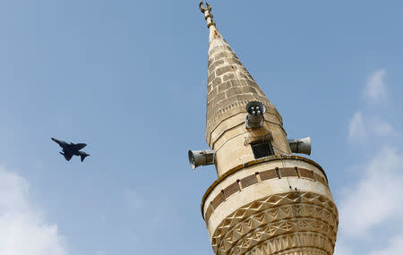 A Turkish Air Force F-16 fighter flies over a minaret after it took off from Incirlik air base in Adana, Turkey, August 12, 2015. REUTERS/Murad Sezer/File Photo