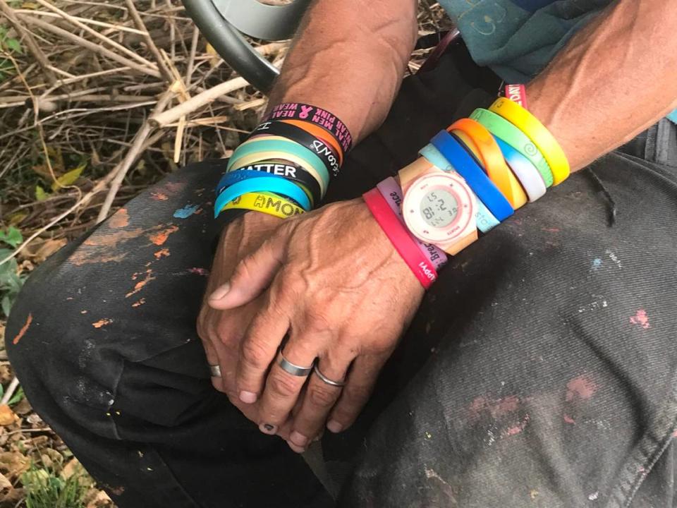 Jerry Crowell wears around twenty rainbow-colored rubber bracelets outside A Splash of Life, his informal donation distribution center on Troost Ave, on Wednesday, July 27.