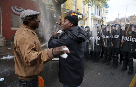 A Baltimore resident (R) trying to restore order in his neighborhood speaks to a protester during clashes in Baltimore, Maryland April 27, 2015. REUTERS/Jim Bourg