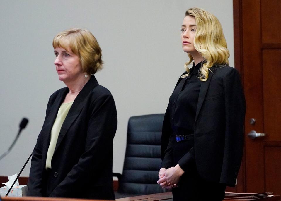 Actress Amber Heard, right, stands next to her attorney Elaine Bredehoft,