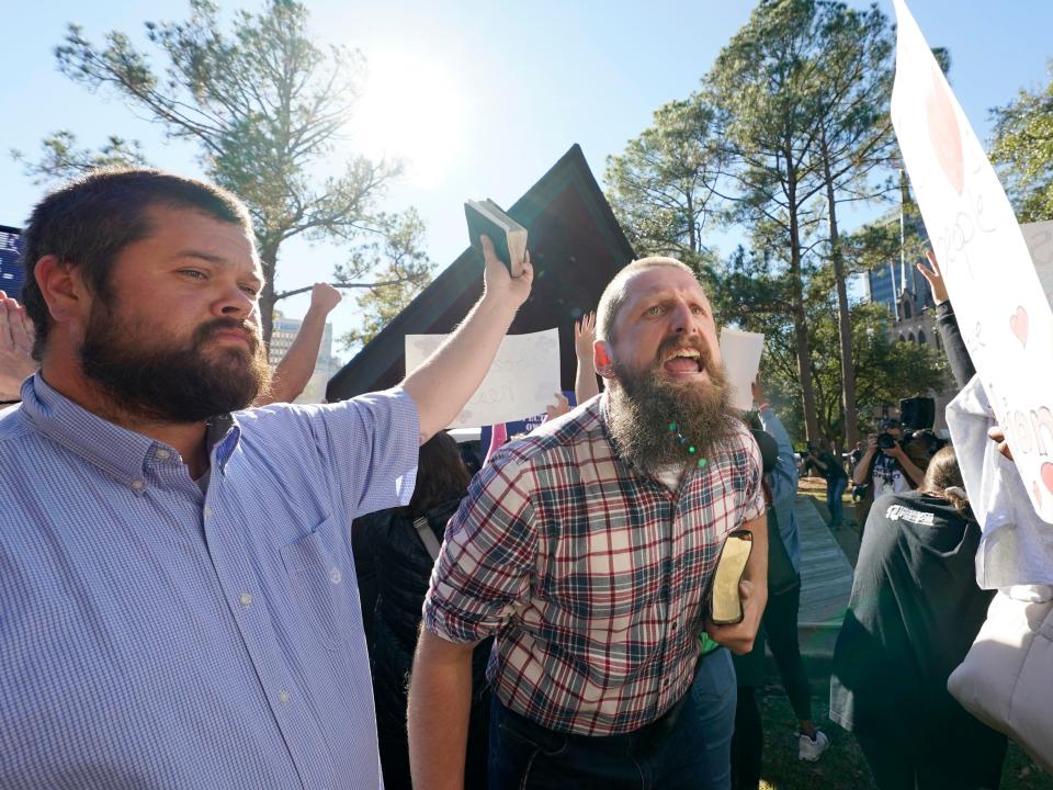 Anti-abortion activists Allen Siders, center, and Pastor Keith Dalton, of the Church at Jackson, call out at speakers during an abortion rights rally in Jackson, Mississippi, Wednesday, Dec. 1, 2021.