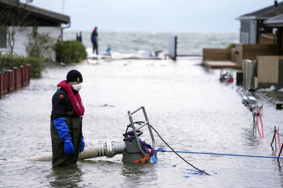 A worker tries to pump water away his neighborhood in Haderslev, Denmark, Friday, Oct. 20. 2023. Authorities across Scandinavia on Friday urged vigilance as the region braced for heavy rain and gale-force winds from the east that was expected to culminate in the evening as a severe storm continued to sweep across northern Europe. The gale-force winds are expected to hit hardest in the eastern part of Denmark's Jutland peninsula and the Danish islands in the Baltic Sea. (Claus Fisker/Ritzau Scanpix via AP)