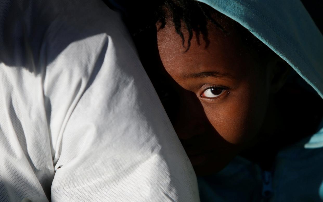 A migrant child sits on the deck of the Malta-based NGO Migrant Offshore Aid Station (MOAS) ship Phoenix as it arrives with migrants and bodies on board, in Augusta, Italy - REUTERS