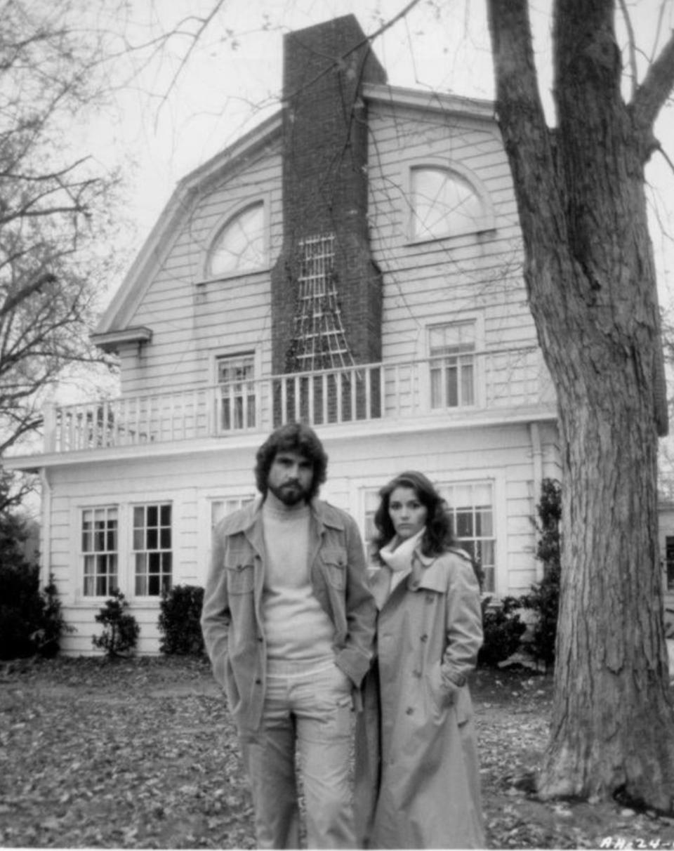 a couple standing outside of a house