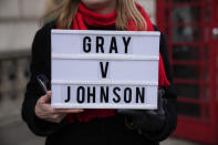 FILE - An anti-Boris Johnson protester holds a placard as a reference to the Sue Gray report, on the junction of Parliament Street and Parliament Square, in London, Wednesday, Jan. 26, 2022. Gray is a senior but previously obscure civil servant who may hold British Prime Minister Boris Johnson's political future in her hands. She has the job of investigating allegations that the prime minister and his staff attended lockdown-flouting parties on government property. AP Photo/Matt Dunham, File)